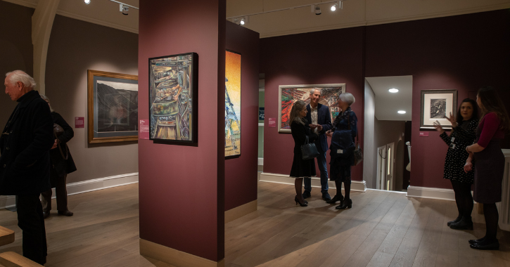 People stood looking at paintings in the Mining Art Gallery, Bishop Auckland.